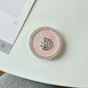 Macro shot of rhinestone-encrusted flower phone grip with pink pleated texture detail