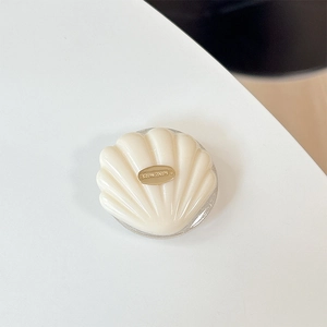 Detail of a creamy 3D shell phone grip featuring a gold plate with Hand Made engraving