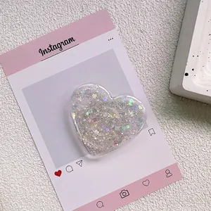 Gros plan d'un support de téléphone cœur avec paillettes colorées et sequins brillants