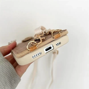 Detail of crossbody phone case with precise cutouts and gold metal ring hook for strap