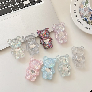 Sparkly glitter bear phone sockets in diverse colors on a laptop and ceramic plate