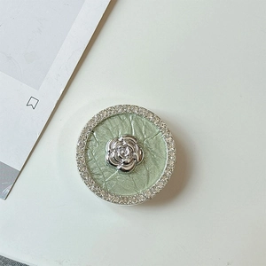 Detail of floral rhinestones and silver camellia design on phone collapsible socket