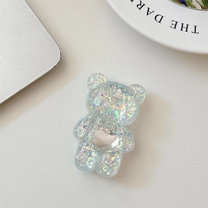 Close-up of bear-shaped phone grip with iridescent sequins and silver heart detail