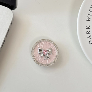 Close-up of pink leather phone grip with silver bow and crystal rhinestone border