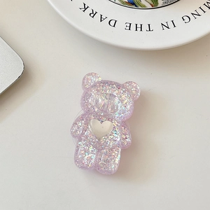 Close-up of bear-shaped phone grip with purple glitter and white heart detail