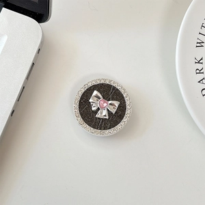 Detailed view of rhinestone phone grip with silver bow and pink heart crystal decoration