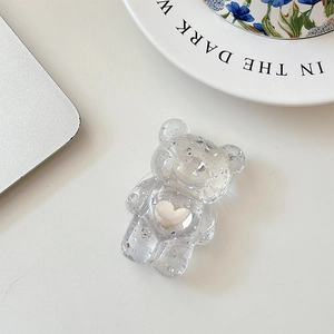 Close-up of bear phone socket with silver glitter and heart cutout on a desk