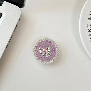 Macro shot of rhinestone bow phone grip with purple texture and pink heart gem