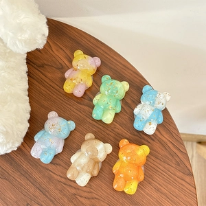 Transparent bear phone grip with gold foil in six vibrant gradient colors on wood