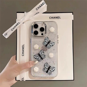 Macro detail of 3D blue butterflies and white camellia flowers on glitter phone case