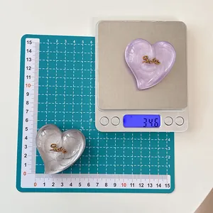 Détail du support de téléphone cœur avec lettrage Smile montrant le poids 34,6g et 5,5cm