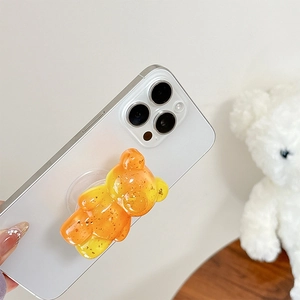 Close-up of clear resin bear phone grip with gold foil flakes and orange gradient finish