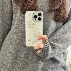 Detail of luxury pearl and silver butterfly case with white marble texture on iPhone
