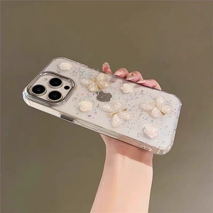 Detail of clear iPhone case featuring 3D white roses, gold-edged butterflies and glitter