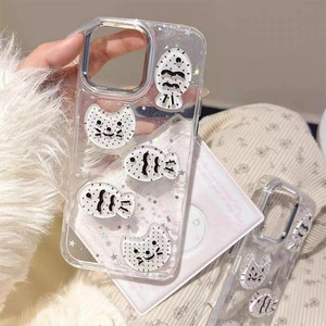 Macro detail of clear glitter phone case with 3D cartoon cat and fish charms for iPhone