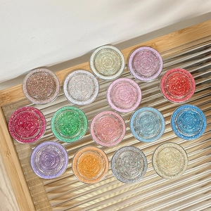 Glitter MagSafe grip sockets in 14 vibrant colors on a textured glass display tray
