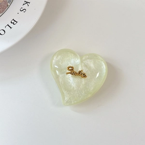 Gros plan d'un support de téléphone en forme de cœur à paillettes avec décor Smile