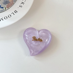 Vue rapprochée d'un support cœur pailleté violet avec emblème Smile doré dessus