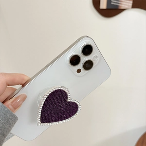 Dettaglio del supporto per telefono a cuore con texture glitter viola e strass