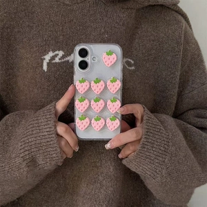 Pink 3D strawberry glitter clear case for iPhone 15 Pro Max held in hands with cozy vibe