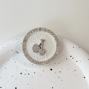 Detailed close-up of a silver rhinestone cherry phone socket on a ceramic plate