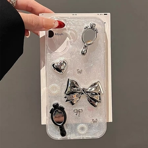 Macro detail of electroplated mirror bow and heart charms on glitter iPhone case