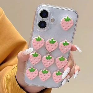 Detail of 3D pink strawberry charms on a clear glitter case for iPhone with protective edges