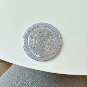 Macro shot of silver holographic glitter MagSafe phone grip on a white surface