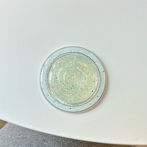 Macro detail of round MagSafe grip featuring colorful glitter and iridescent foils
