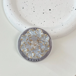 Close-up of pearl white flower phone socket with gold trim and Gift For You text