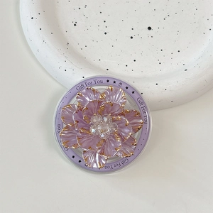 Close-up of floral phone socket with purple petals, gold edges and rhinestone center