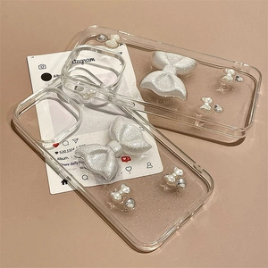 Close-up of clear iPhone case with 3D silver glitter bow and pearl rhinestone details