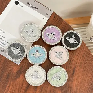 Sparkly rhinestone planet phone socket grips in various colors on wooden background