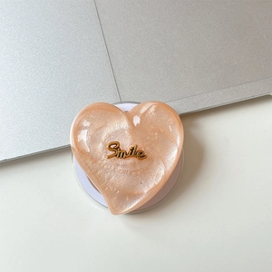 Detail of pink heart-shaped glitter MagSafe phone grip with gold Smile lettering
