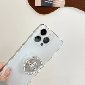 Macro detail of rhinestone planet phone grip featuring a sparkling orb on a white phone