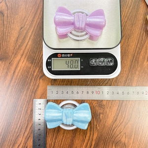 Measurement of glitter bow phone grip size and 48g weight on scale for stability