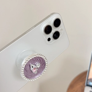 Close-up of a purple rhinestone planet phone grip showing orbit design on white phone