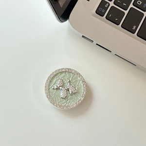 Detail of a sparkling rhinestone balloon dog phone socket with light green pleated base