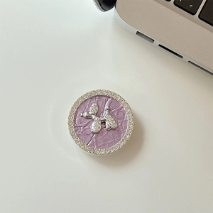Detail of a purple leather texture phone grip with a sparkling silver rhinestone puppy dog