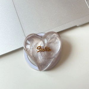 Detail view of heart-shaped MagSafe grip with silver pearlescent finish and Smile text