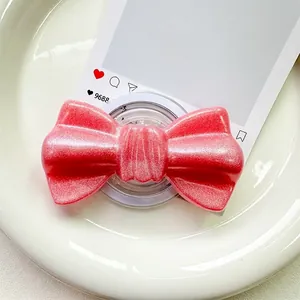 Macro view of pink glitter bow phone grip featuring shimmering pearlescent particles