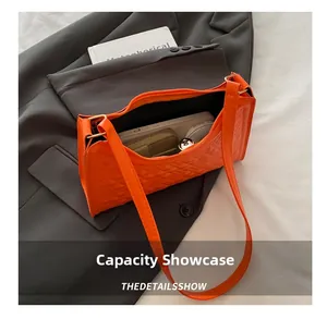 Interior view showing the capacity of an orange quilted faux leather underarm bag