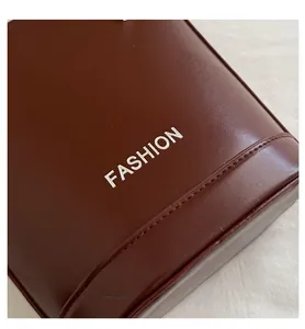 Close-up of deep brown leather bucket bag with silver Fashion print and neat stitching