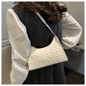 Close-up of white underarm bag with stereoscopic diamond lattice texture on PU leather