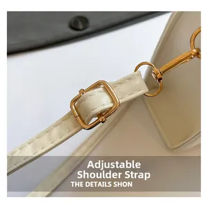 Detail view of the adjustable off-white shoulder strap with golden metal buckle and lobster clasp