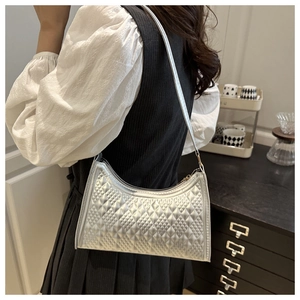 Silver metallic crescent underarm bag with diamond texture worn by a model