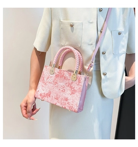 Detailed view of pink floral jacquard fabric and gold metal accents on crossbody bag