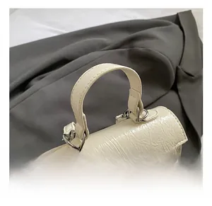 Détail du sac plissé blanc crème avec fermoir argenté et poignée supérieure lisse