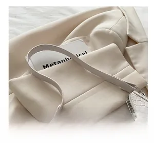 Détail du sac croissant crème avec texture crocodile et boucle élégante en métal argenté