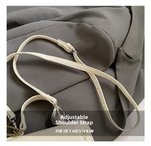 Détail de la bandoulière réglable en cuir beige avec boucles métalliques argentées